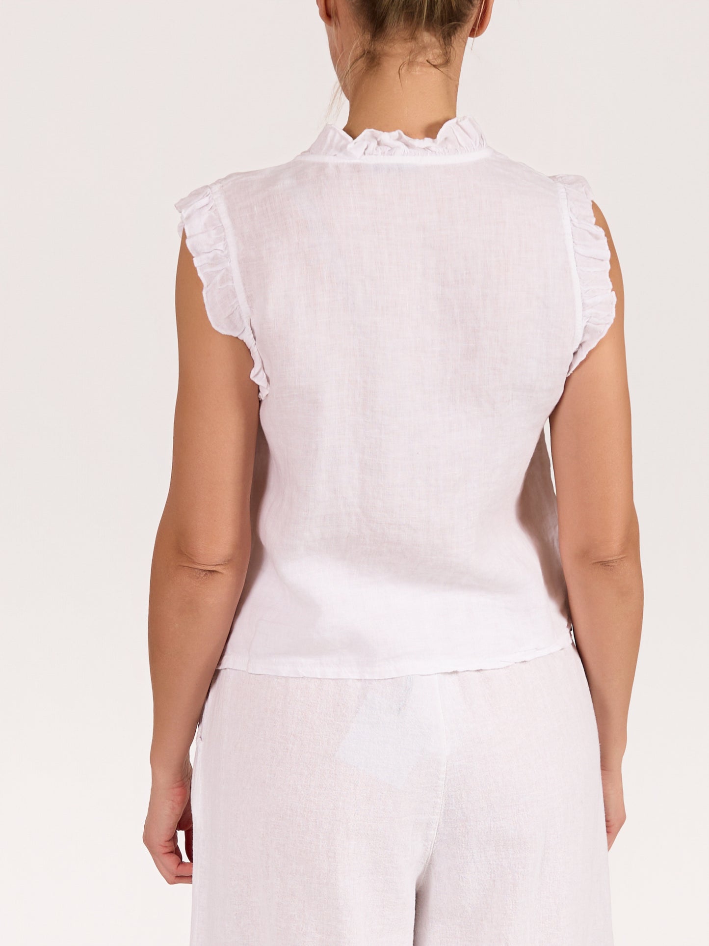 Blouse blanche sans manches à volants boutonnée