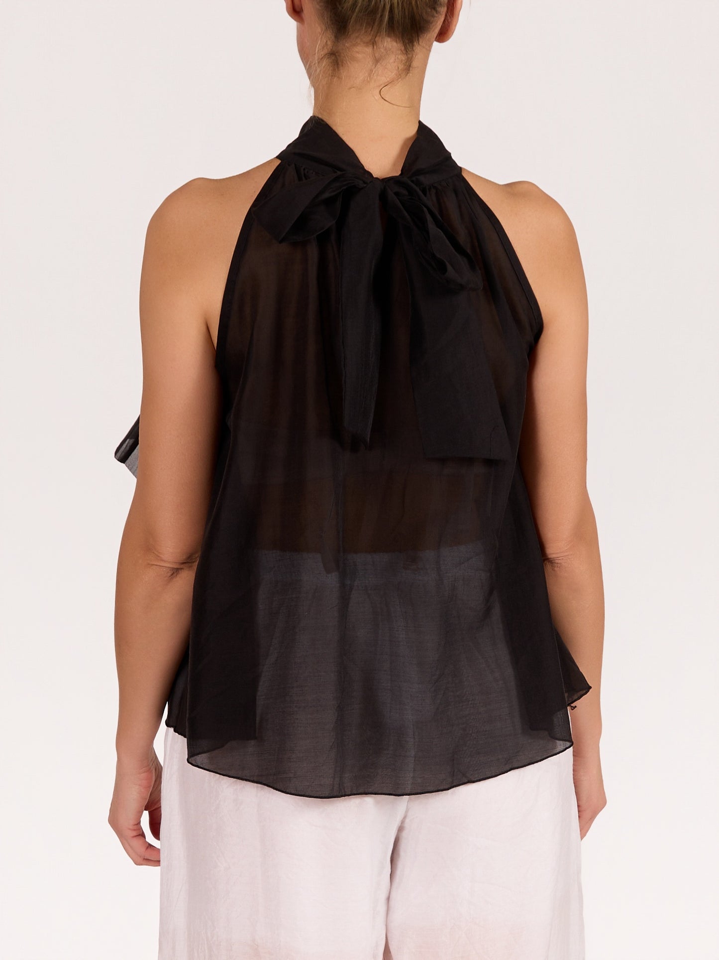 Blouse noire sans manches avec nœud et volants à l’avant