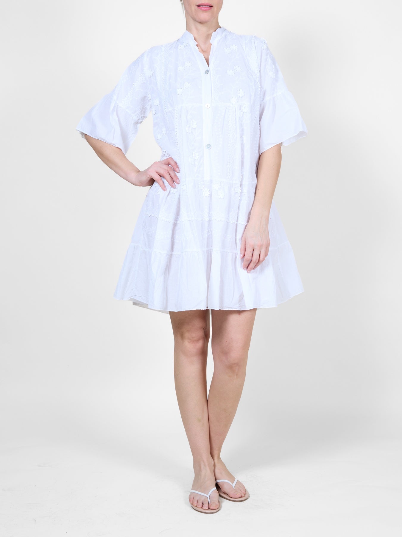 Robe blanche ornée de volants et de broderies florales