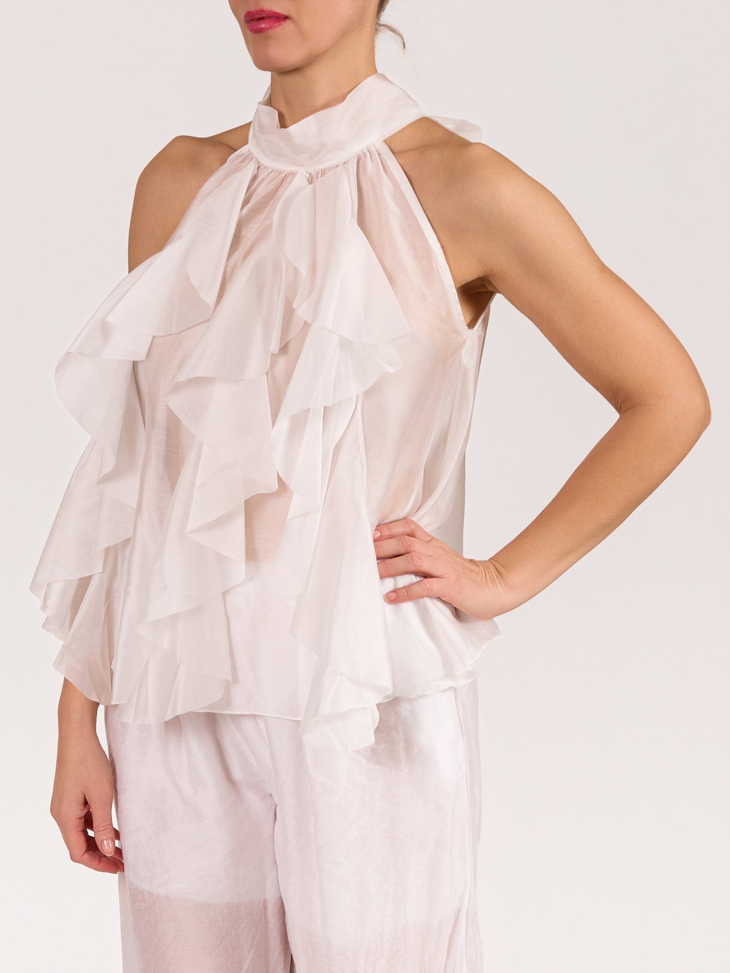 Blouse blanche sans manches avec nœud et volants à l’avant