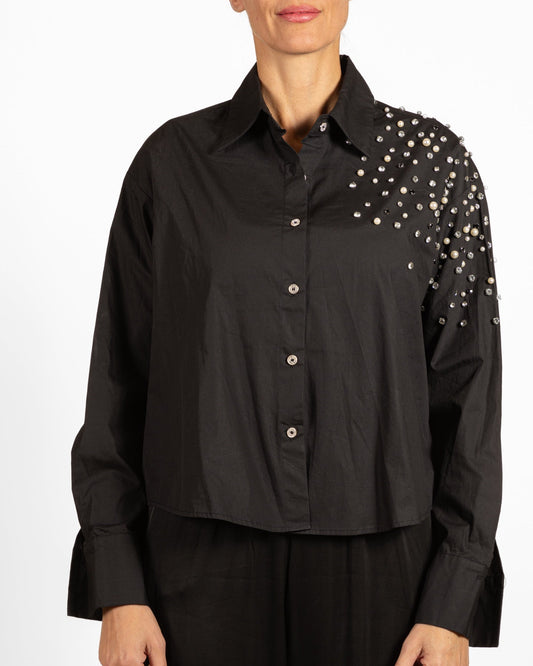 Haut noir boutonné sur le devant, orné de strass et de perles aux épaules.