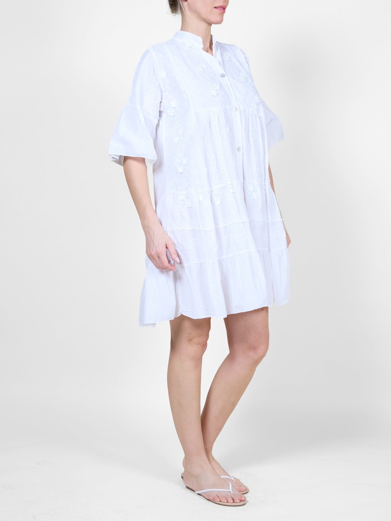Robe blanche ornée de volants et de broderies florales