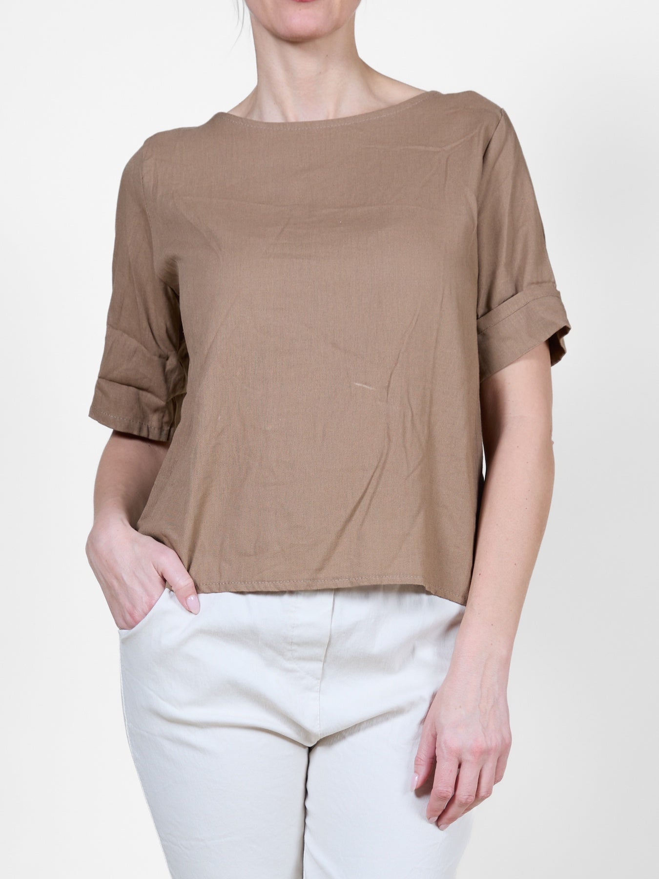 Chemisier T-shirt beige à manches courtes et poignets retroussés, fermeture boutonnée au dos