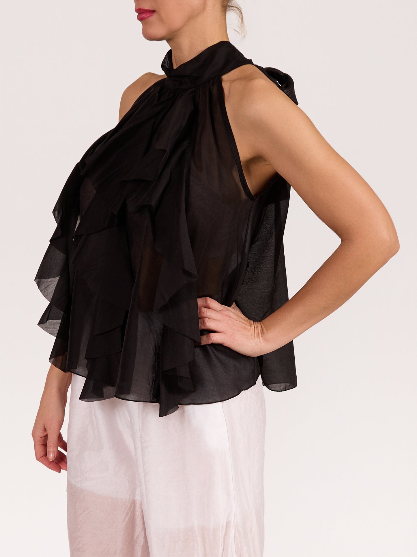 Blouse noire sans manches avec nœud et volants à l’avant