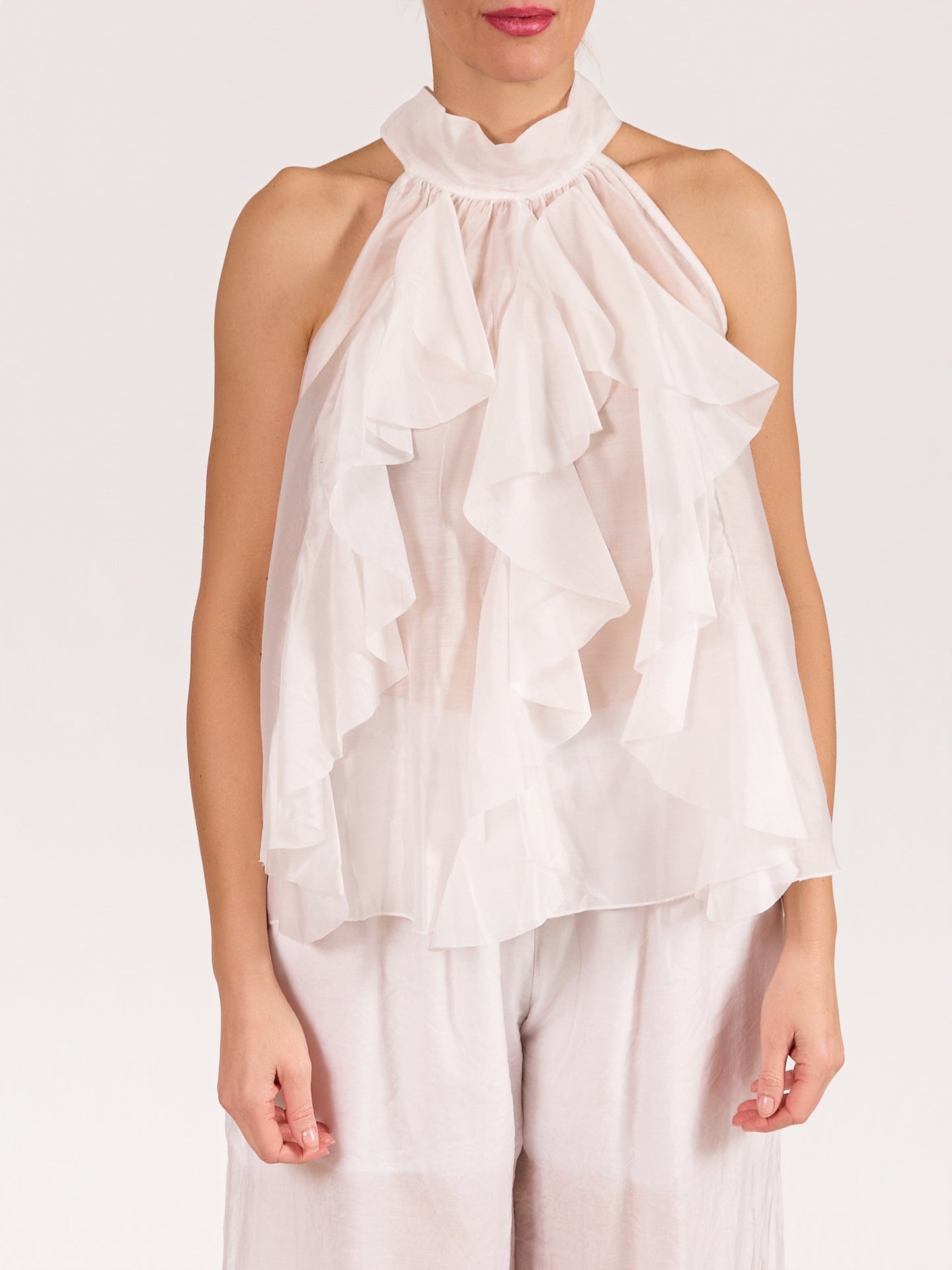 Blouse blanche sans manches avec nœud et volants à l’avant